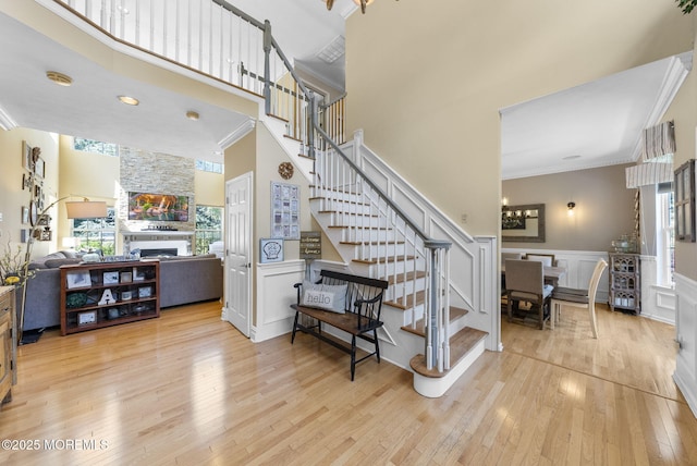 6 Tower Ct, Farmingdale, NJ 07727 - stairway with plenty of natural light, crown molding, hardwood / wood-style floors, a towering ceiling, and a fireplace