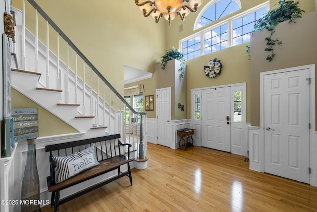6 Tower Ct, Farmingdale, NJ 07727 - foyer with a chandelier, stairway, hardwood / wood-style flooring, a wainscoted wall, and a towering ceiling