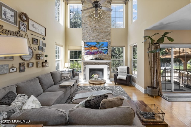 6 Tower Ct, Farmingdale, NJ 07727 - living area with plenty of natural light, ceiling fan, a towering ceiling, a glass covered fireplace, and wood finished floors