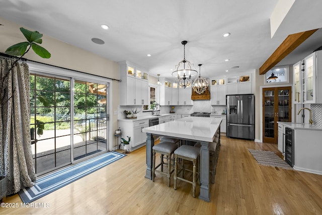 6 Tower Ct, Farmingdale, NJ 07727 - kitchen with stainless steel refrigerator with ice dispenser, a chandelier, decorative backsplash, a kitchen island, and a kitchen bar