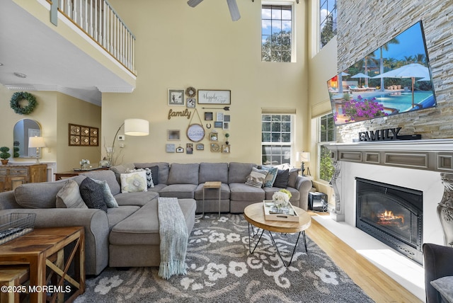 6 Tower Ct, Farmingdale, NJ 07727 - living room featuring a high ceiling, wood finished floors, plenty of natural light, a glass covered fireplace, and ornamental molding