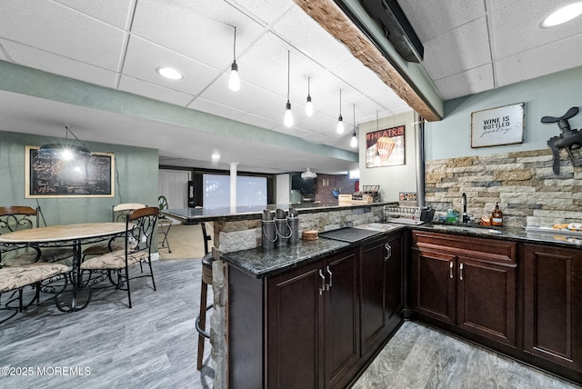 6 Tower Ct, Farmingdale, NJ 07727 - kitchen featuring light wood-style floors, a peninsula, dark stone countertops, decorative backsplash, and a paneled ceiling