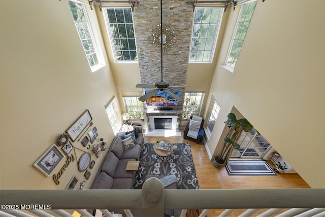 6 Tower Ct, Farmingdale, NJ 07727 - living area featuring healthy amount of natural light, a high ceiling, a glass covered fireplace, and wood finished floors
