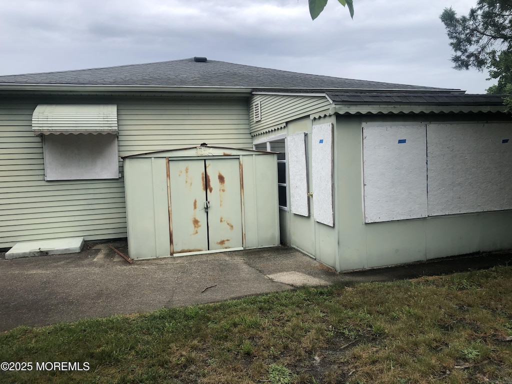 12 Tortola St, Toms River, NJ 08757 - rear view of house with a storage unit and a shingled roof