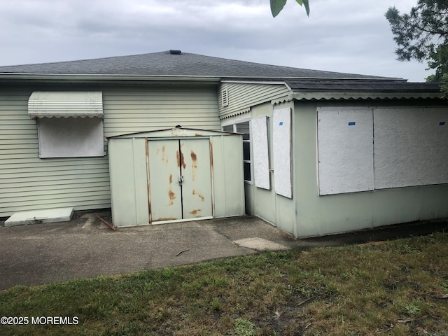 12 Tortola St, Toms River, NJ 08757 - rear view of house with a storage unit and a shingled roof
