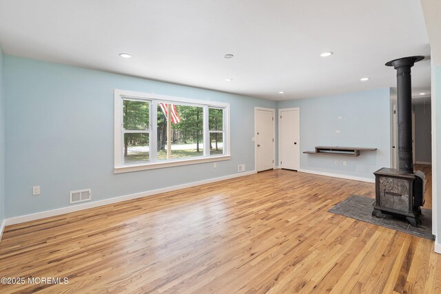 271 S Stump Tavern Rd, Jackson, NJ 08527 - unfurnished living room featuring wood finished floors, a wood stove, and recessed lighting