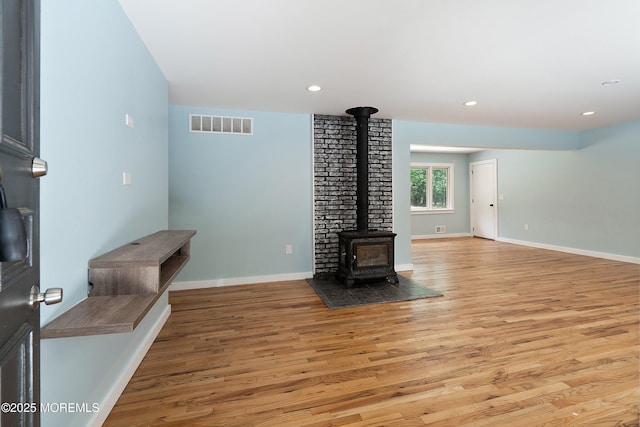271 S Stump Tavern Rd, Jackson, NJ 08527 - unfurnished living room with a wood stove, light wood-style flooring, and recessed lighting