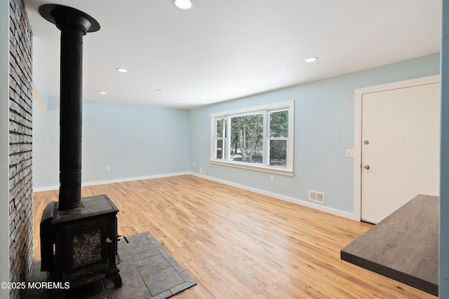 271 S Stump Tavern Rd, Jackson, NJ 08527 - unfurnished living room with a wood stove, wood finished floors, and recessed lighting