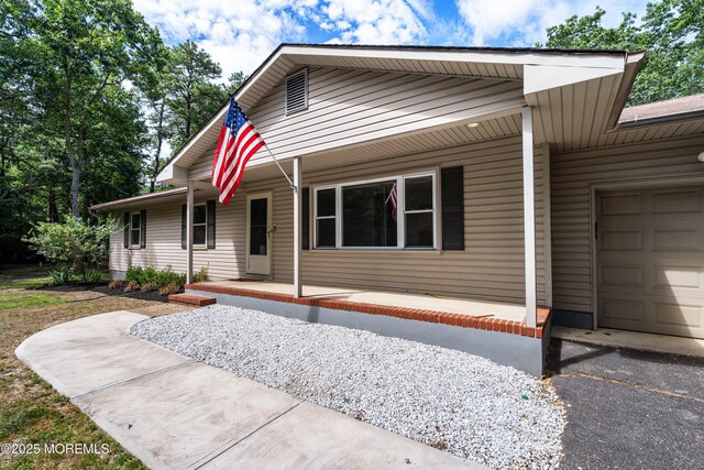 271 S Stump Tavern Rd, Jackson, NJ 08527 - view of front of home with covered porch, a garage, and asphalt driveway
