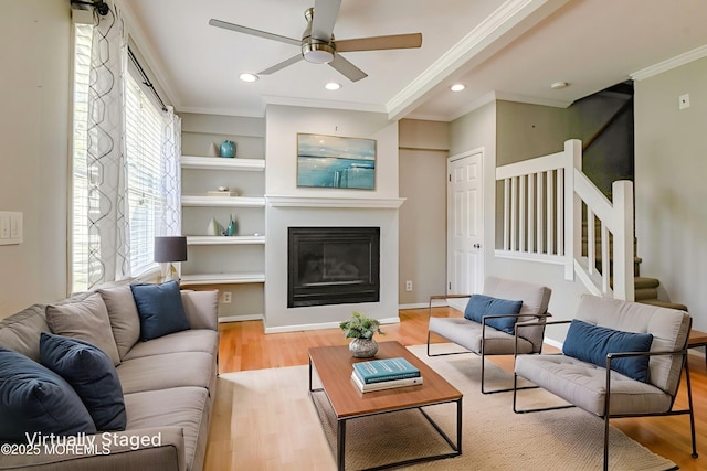 48 Washington Ave, Leonardo, NJ 07737 - living room featuring crown molding, light wood-style floors, a ceiling fan, stairs, and a glass covered fireplace