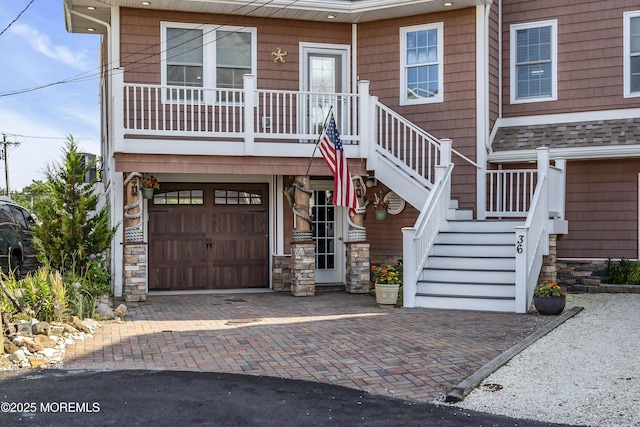36 Joy Rd, Manahawkin, NJ 08050 - view of front facade with stone siding, decorative driveway, an attached garage, and stairway