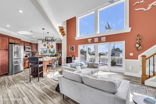36 Joy Rd, Manahawkin, NJ 08050 - living area with ornamental molding, healthy amount of natural light, stairway, light wood-type flooring, and a wainscoted wall