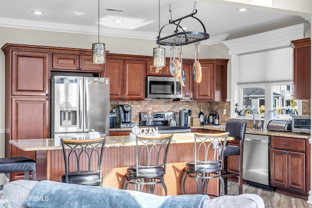 36 Joy Rd, Manahawkin, NJ 08050 - kitchen featuring stainless steel appliances, a breakfast bar, a kitchen island, tasteful backsplash, and pendant lighting