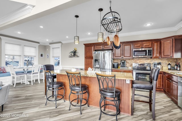 36 Joy Rd, Manahawkin, NJ 08050 - kitchen featuring appliances with stainless steel finishes, ornamental molding, a kitchen island, tasteful backsplash, and light stone counters