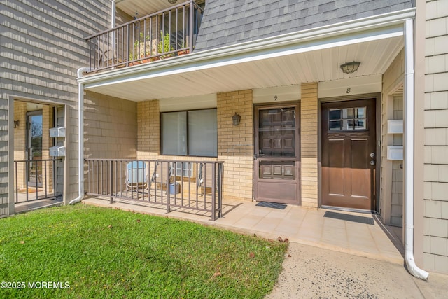 720 Ocean Ave Unit 8, Long Branch, NJ 07740 - view of exterior entry with a porch, roof with shingles, a balcony, and brick siding