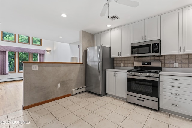 24 Bray Ave, North Middletown, NJ 07748 - kitchen featuring appliances with stainless steel finishes, a baseboard radiator, a ceiling fan, a baseboard heating unit, and backsplash