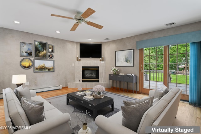 24 Bray Ave, North Middletown, NJ 07748 - living room with a baseboard heating unit, wood finished floors, ceiling fan, a tile fireplace, and recessed lighting