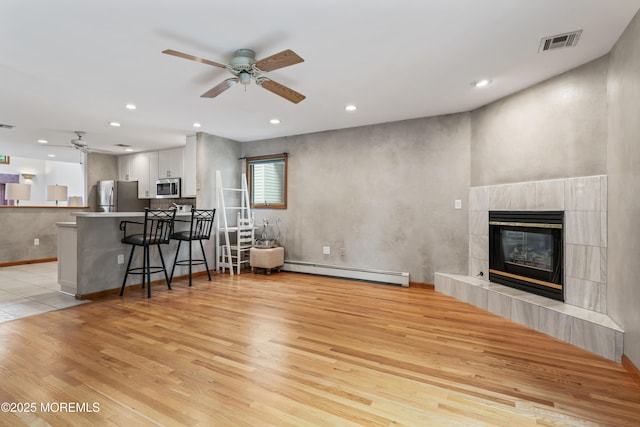 24 Bray Ave, North Middletown, NJ 07748 - living area with baseboard heating, a ceiling fan, light wood finished floors, recessed lighting, and a tile fireplace