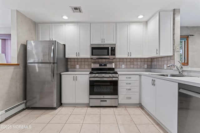 24 Bray Ave, North Middletown, NJ 07748 - kitchen with appliances with stainless steel finishes, baseboard heating, light countertops, white cabinetry, and decorative backsplash
