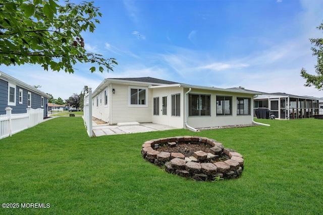 324 Barbados Dr N, Toms River, NJ 08757 - rear view of house featuring a sunroom, a lawn, a fire pit, and a patio