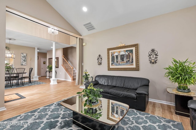 2 Moet Ct, Manchester, NJ 08759 - living room with decorative columns, wood finished floors, stairs, high vaulted ceiling, and a chandelier