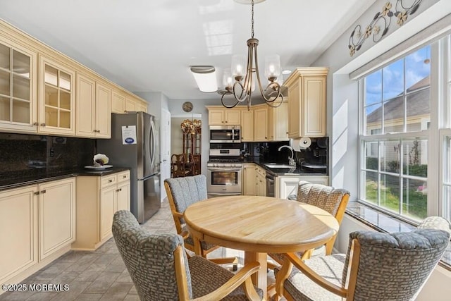 2525 Spring Hill Dr, Toms River, NJ 08755 - kitchen with cream cabinets, stainless steel appliances, dark countertops, and a chandelier