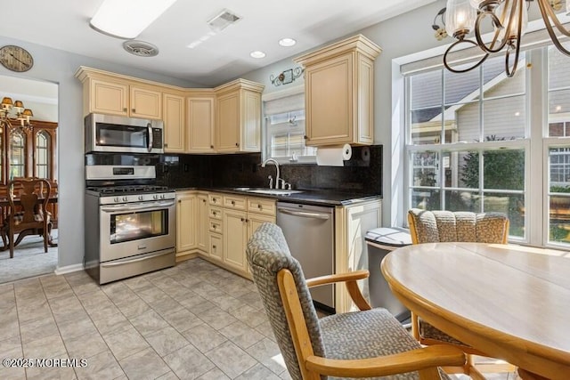 2525 Spring Hill Dr, Toms River, NJ 08755 - kitchen with stainless steel appliances, cream cabinetry, a chandelier, dark countertops, and healthy amount of natural light