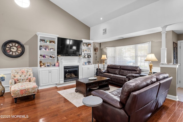 98 Yorkwood Dr, Brick, NJ 08723 - living area with high vaulted ceiling, decorative columns, wood finished floors, a wainscoted wall, and a glass covered fireplace