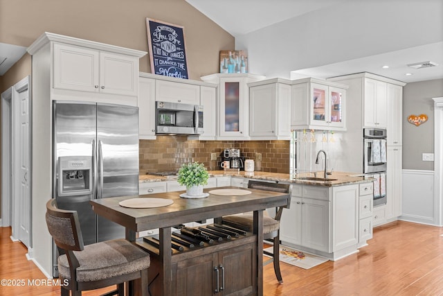 98 Yorkwood Dr, Brick, NJ 08723 - kitchen featuring appliances with stainless steel finishes, light wood-type flooring, tasteful backsplash, glass insert cabinets, and vaulted ceiling