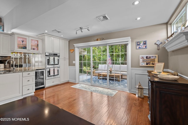 98 Yorkwood Dr, Brick, NJ 08723 - kitchen featuring a wainscoted wall, beverage cooler, light wood finished floors, glass insert cabinets, and white cabinetry