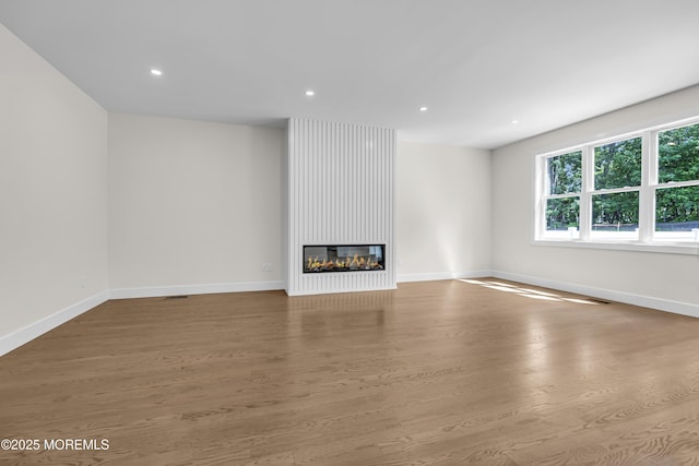 21 Pension Hill Rd, Manalapan, NJ 07726 - unfurnished living room featuring wood finished floors, a large fireplace, and recessed lighting