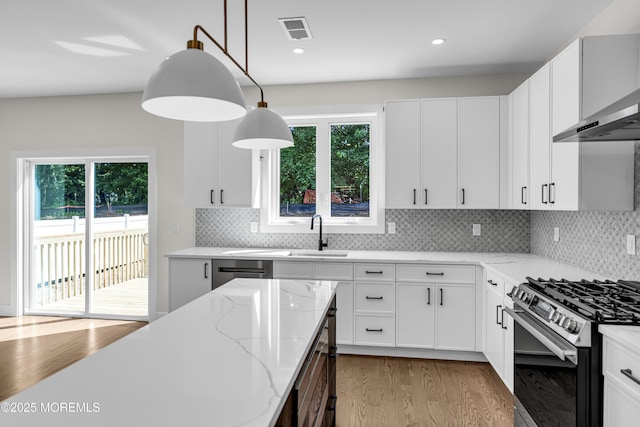 21 Pension Hill Rd, Manalapan, NJ 07726 - kitchen with wall chimney range hood, wood finished floors, light stone countertops, stainless steel appliances, and decorative backsplash