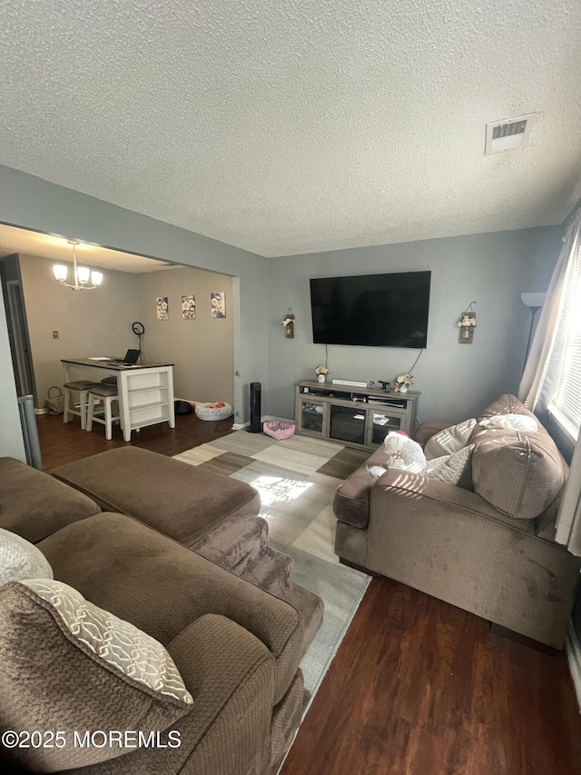 25 Watson Ct, Howell, NJ 07731 - living room with a textured ceiling, wood finished floors, and a chandelier