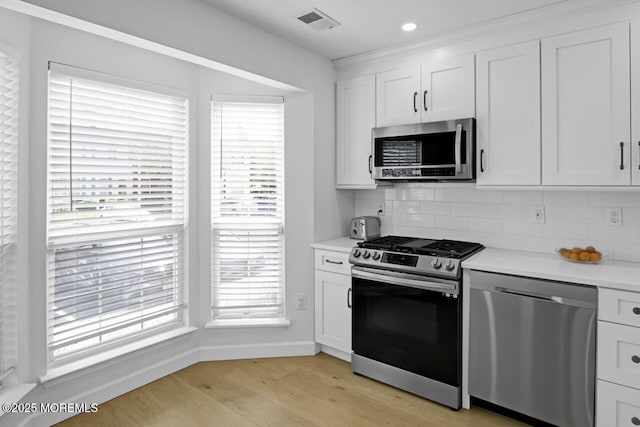 141 Setter Pl, Freehold, NJ 07728 - kitchen featuring stainless steel appliances, light wood-style floors, decorative backsplash, light countertops, and white cabinetry