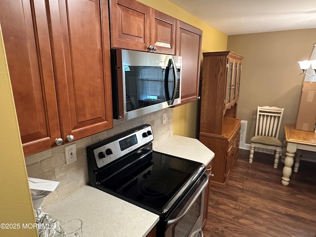 9 Maine Ct Unit 741, Matawan, NJ 07747 - kitchen with appliances with stainless steel finishes, light countertops, dark wood-style floors, tasteful backsplash, and brown cabinets