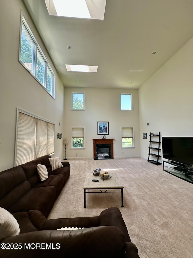 1642 Mink Ct, Toms River, NJ 08755 - carpeted living room with a skylight, a high ceiling, and a glass covered fireplace