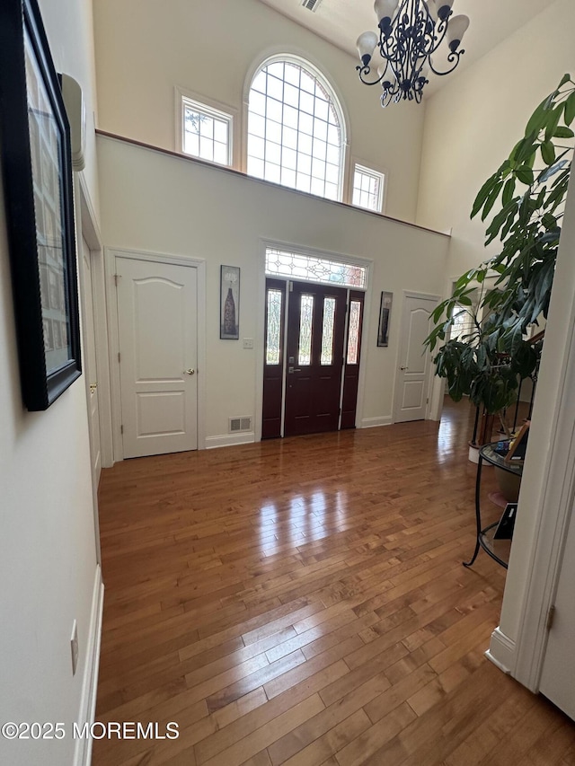 1642 Mink Ct, Toms River, NJ 08755 - foyer featuring a chandelier, hardwood / wood-style flooring, a high ceiling, and plenty of natural light