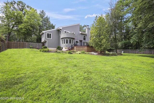 42 Nikki Ct, Morganville, NJ 07751 - rear view of property featuring a fenced backyard, a chimney, and a deck