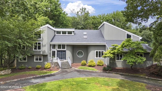 42 Nikki Ct, Morganville, NJ 07751 - mid-century modern home with a shingled roof, driveway, and french doors