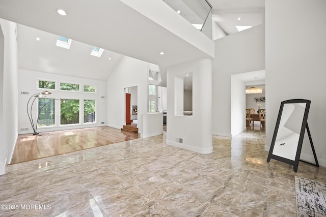 42 Nikki Ct, Morganville, NJ 07751 - unfurnished living room featuring high vaulted ceiling, marble tiled flooring, a skylight, and recessed lighting