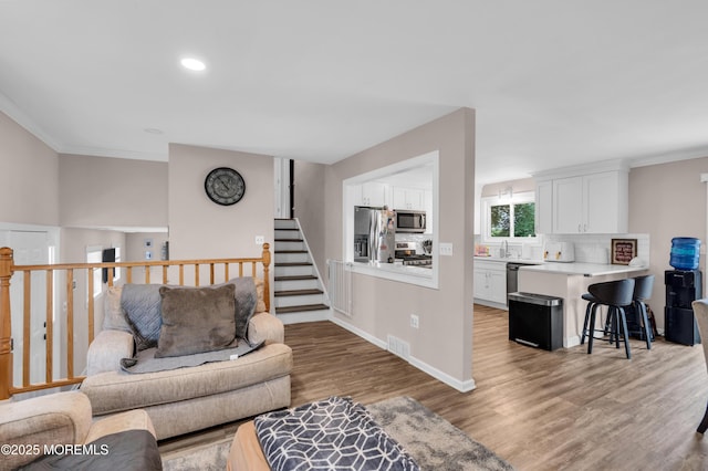 24 Willow Brook Rd, Freehold, NJ 07728 - living room with ornamental molding, wood finished floors, recessed lighting, and stairway