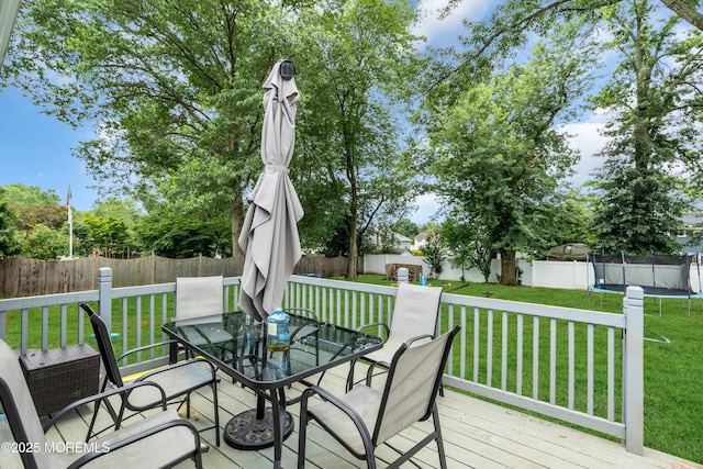 24 Willow Brook Rd, Freehold, NJ 07728 - wooden deck with a trampoline, outdoor dining area, and a fenced backyard