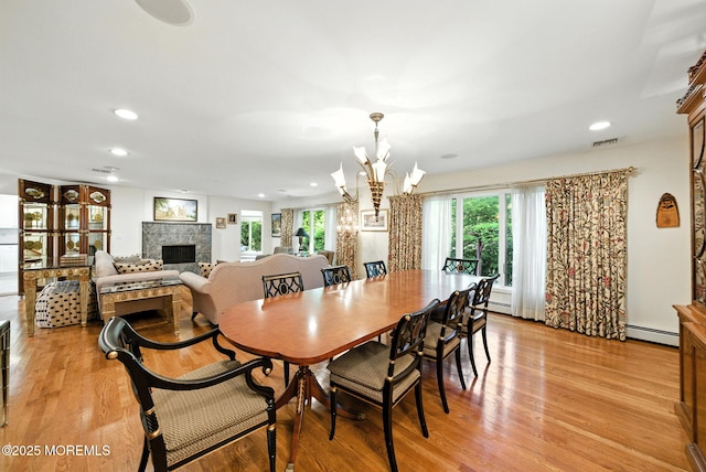 7 Stony Ridge Dr, Hillsdale, NJ 07642 - dining area featuring a fireplace, a chandelier, light wood finished floors, recessed lighting, and a baseboard radiator