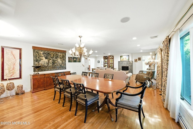 7 Stony Ridge Dr, Hillsdale, NJ 07642 - dining space with a fireplace, a chandelier, light wood finished floors, recessed lighting, and a baseboard heating unit