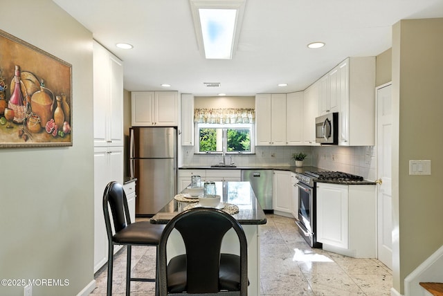 7 Stony Ridge Dr, Hillsdale, NJ 07642 - kitchen featuring appliances with stainless steel finishes, decorative backsplash, white cabinets, a kitchen bar, and recessed lighting
