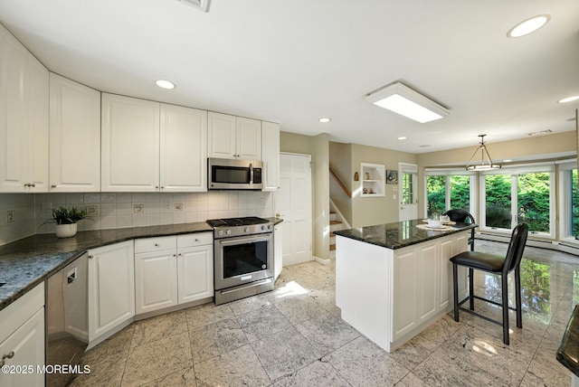 7 Stony Ridge Dr, Hillsdale, NJ 07642 - kitchen featuring appliances with stainless steel finishes, tasteful backsplash, white cabinetry, a kitchen island, and recessed lighting