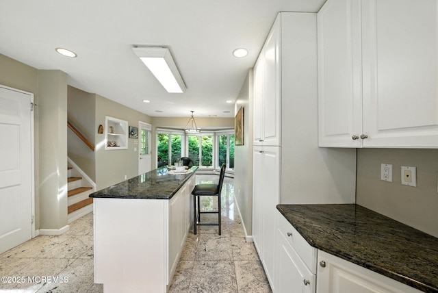 7 Stony Ridge Dr, Hillsdale, NJ 07642 - kitchen with recessed lighting, white cabinets, a kitchen island, dark stone counters, and a breakfast bar