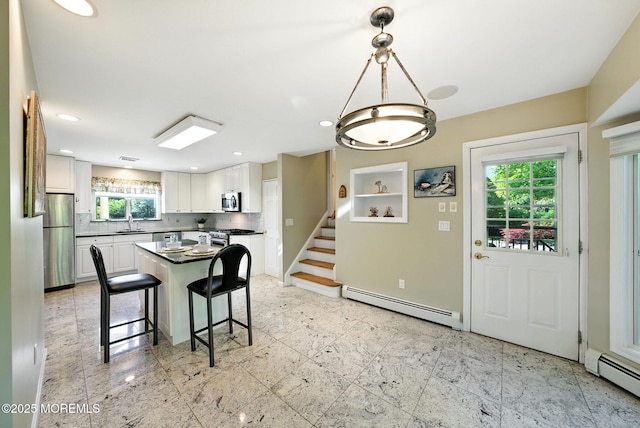 7 Stony Ridge Dr, Hillsdale, NJ 07642 - kitchen featuring a baseboard radiator, dark countertops, white cabinets, decorative backsplash, and a breakfast bar area