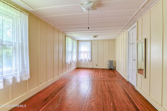 1416 Garven Ave, Ocean Twp, NJ 07712 - spare room with radiator, wood-type flooring, and a decorative wall