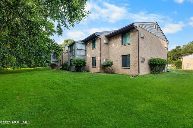 229 Medford Ct Unit B, Manalapan, NJ 07726 - back of house with brick siding and a lawn